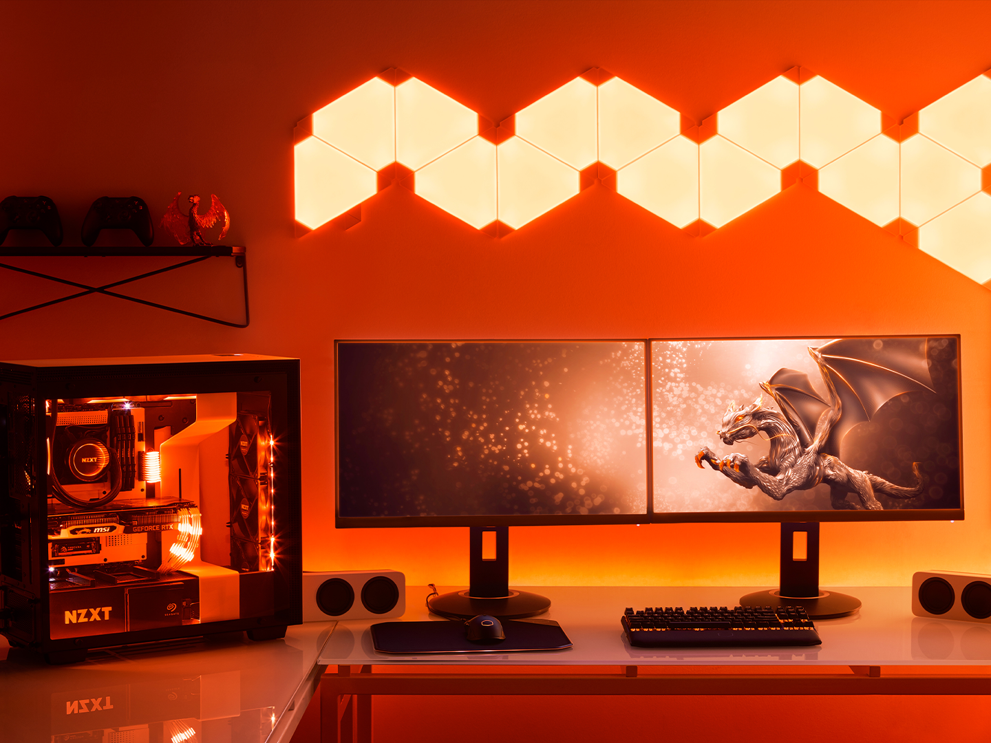 See-through hard drive is displayed next to mini speakers, dual screens, and headphones as part of a gaming set up.