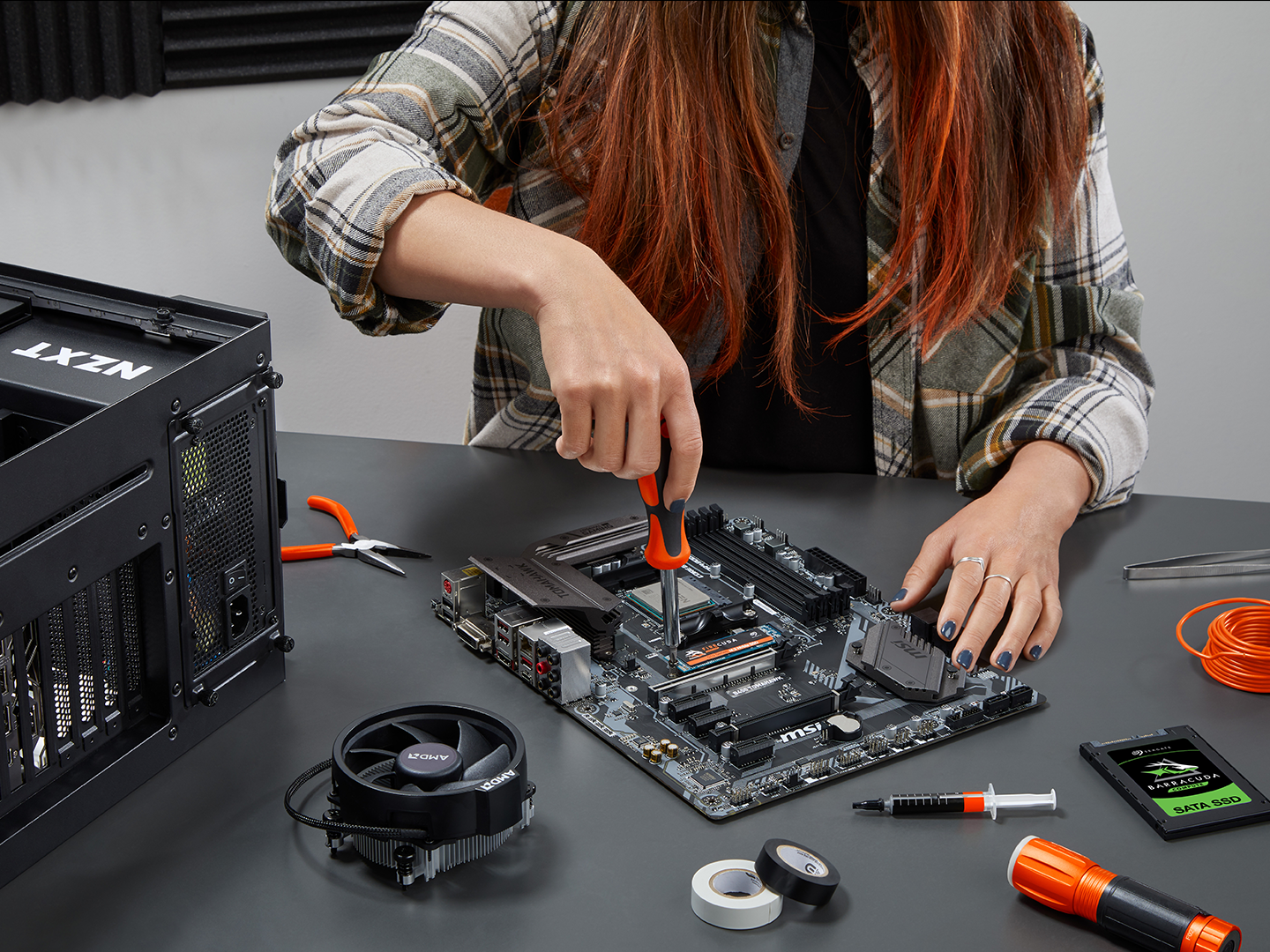 A person installs a drive into a system using a screwdriver.