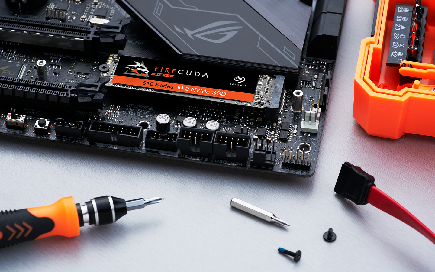 Up-close shot of a FireCuda SSD inserted in an open laptop with a screwdriver and screws in the forefront.