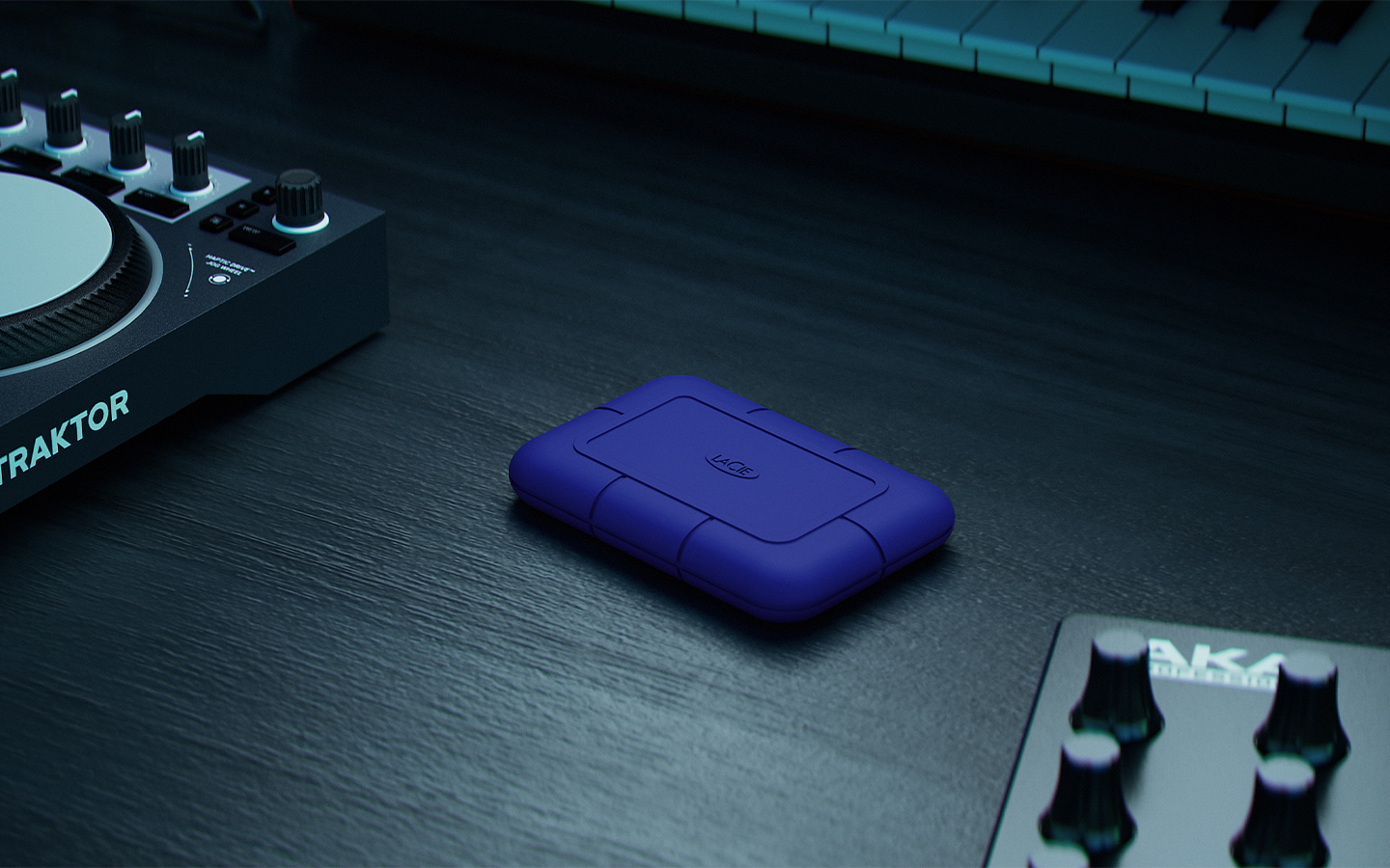 A LaCie Rugged SSD Pro5 sits on a table at the center of sound studio equipment.