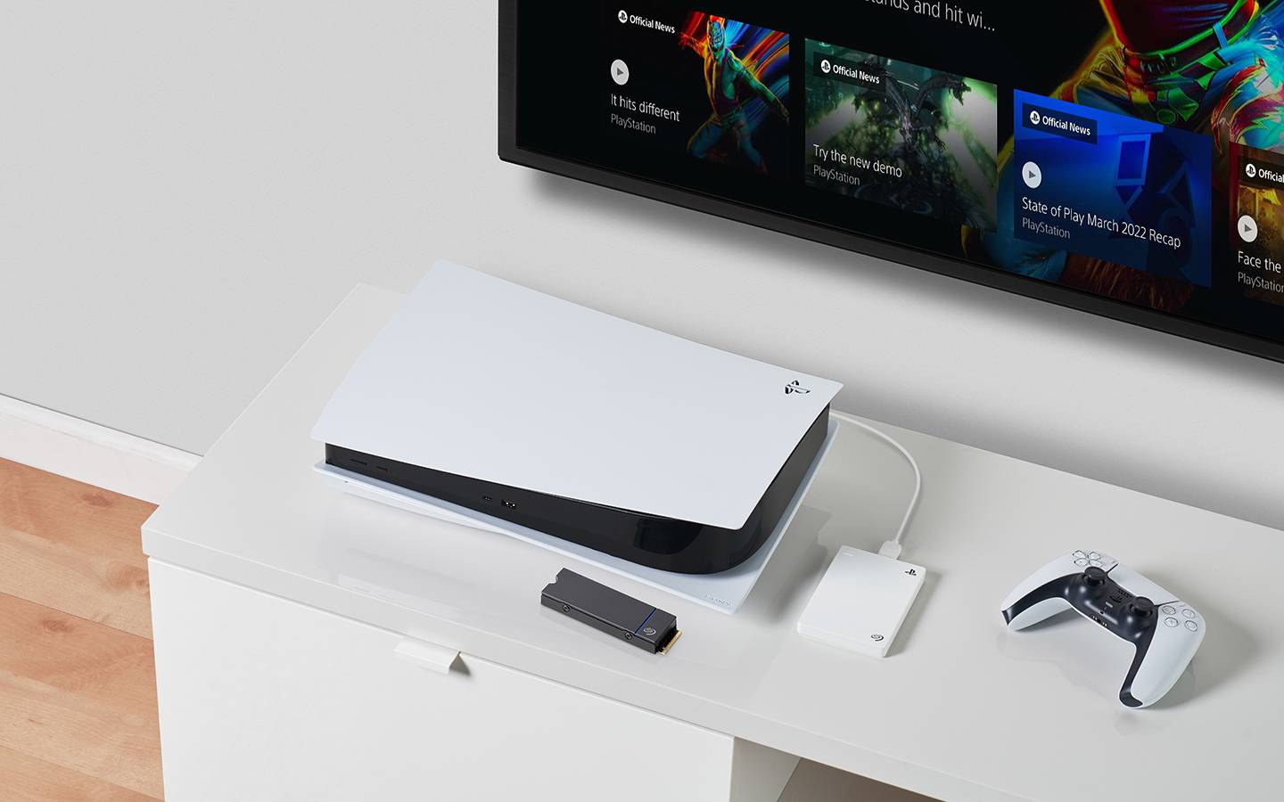 White Seagate PlayStation portable hard drive connected to a white PS5 system is displayed with a controller and game on screen.