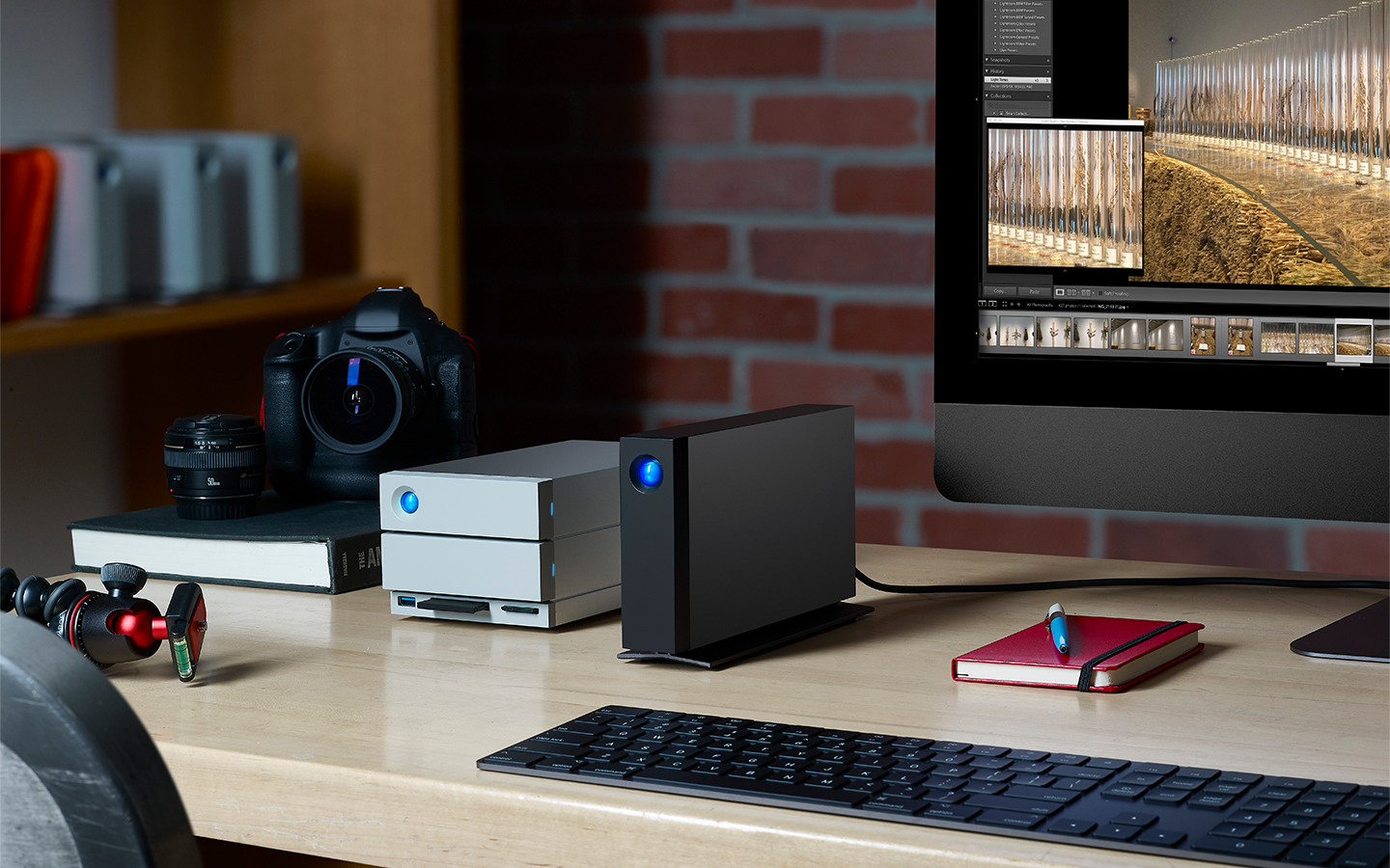 Photo editing setup features LaCie 2big RAID, d2 Professional, desktop screen, camera, notebook, and keyboard.