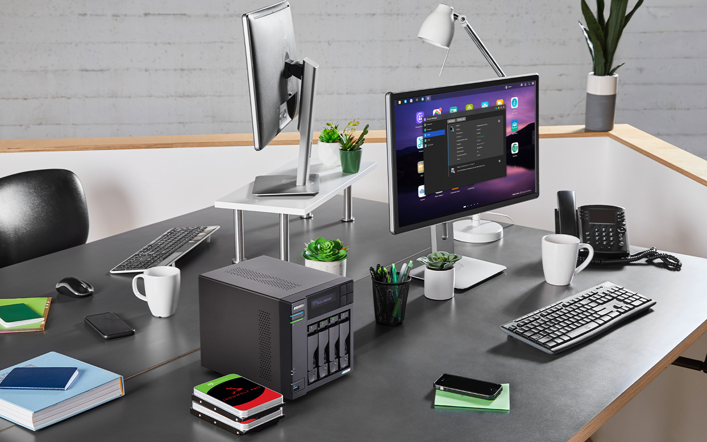 Two stacked IronWolf Pro drives sit beside a NAS system, centered between two facing office desks with screens, keyboards, and supplies.
