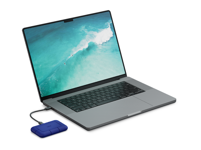 A LaCie Rugged Pro5 drive is shown plugged into a laptop.