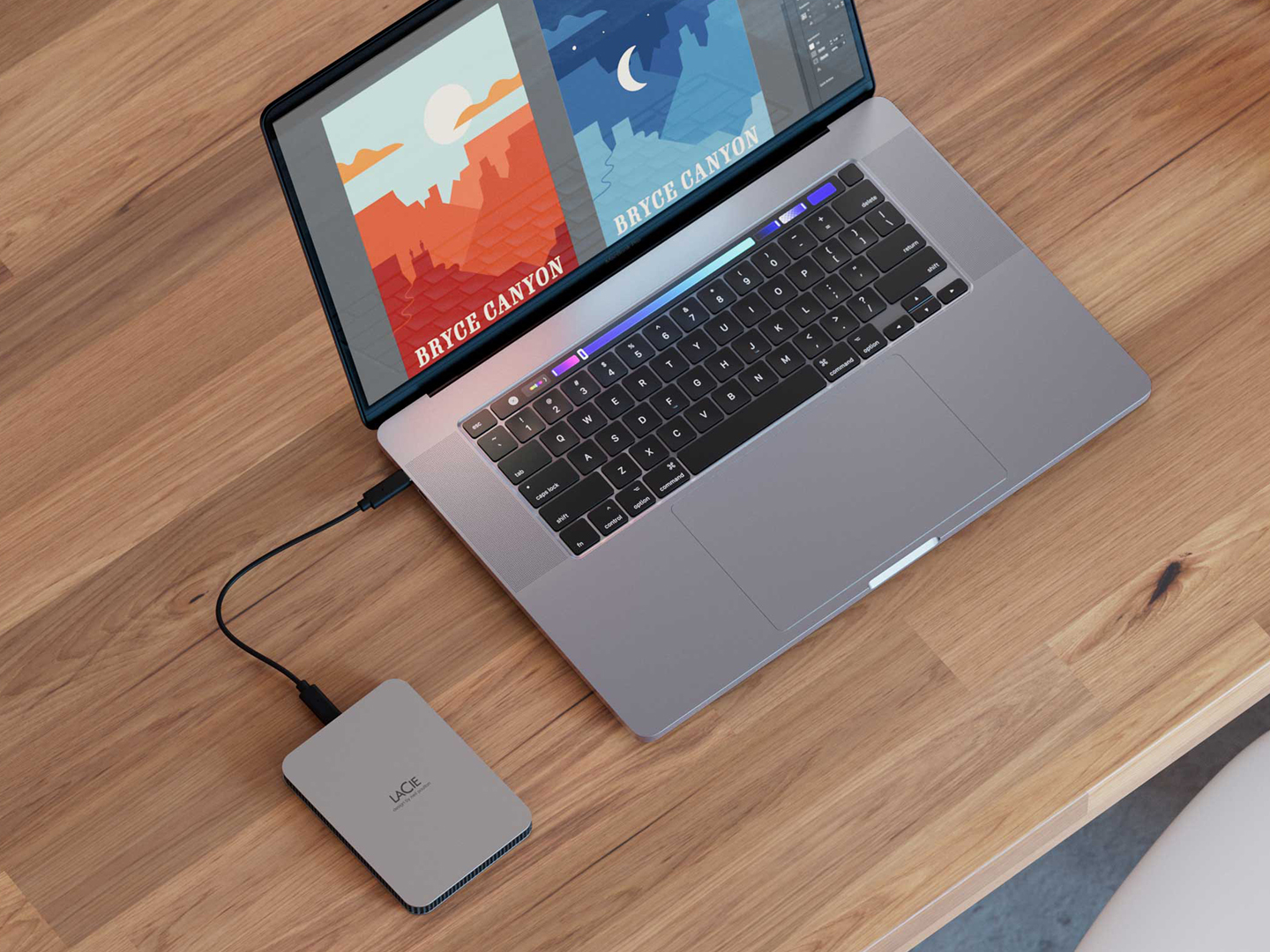 A LaCie® portable external hard drive connected to a laptop and sitting on a wooden table.